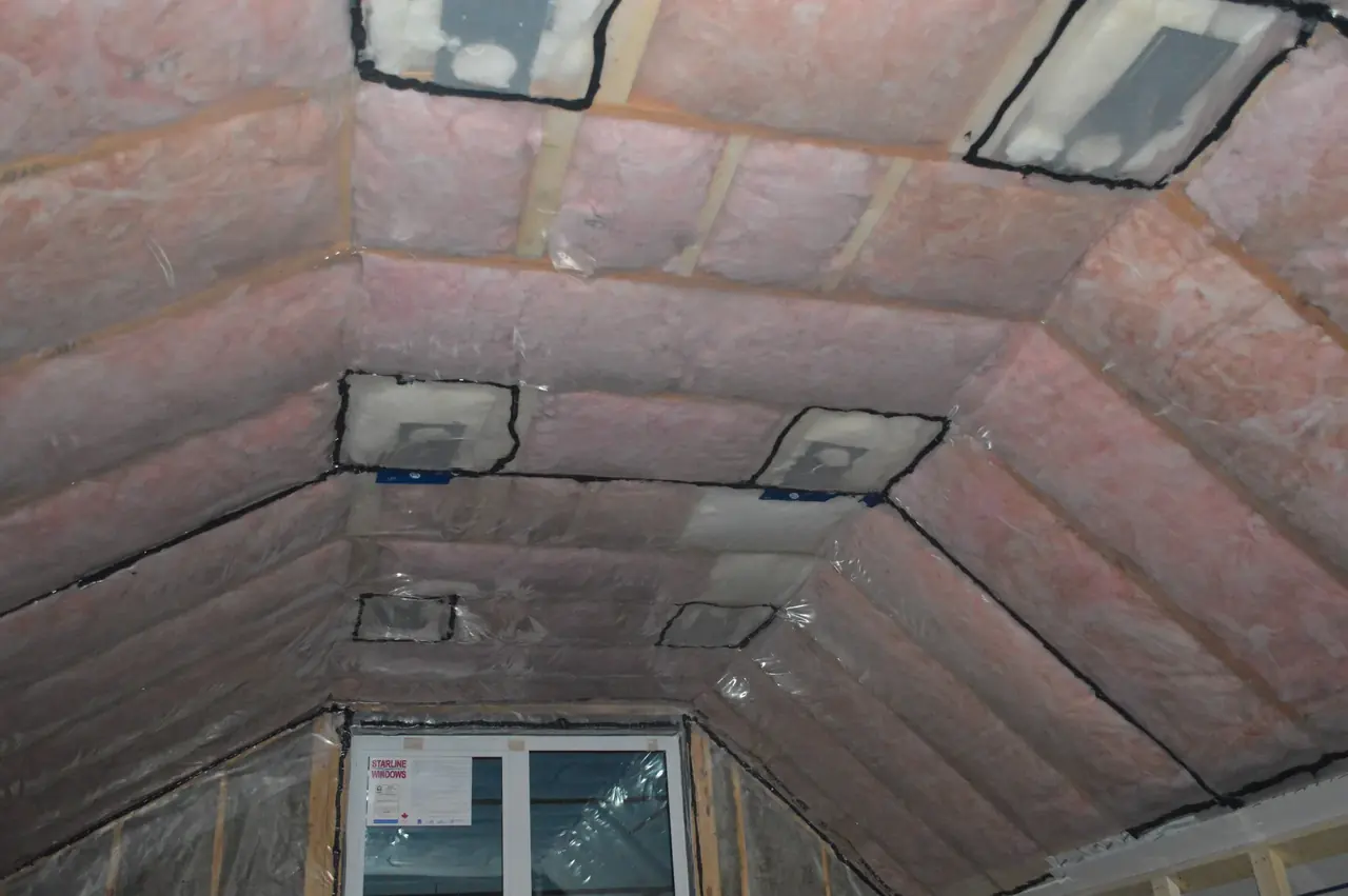 Fibreglass batt insulation fitted between the rafters of a vaulted attic.