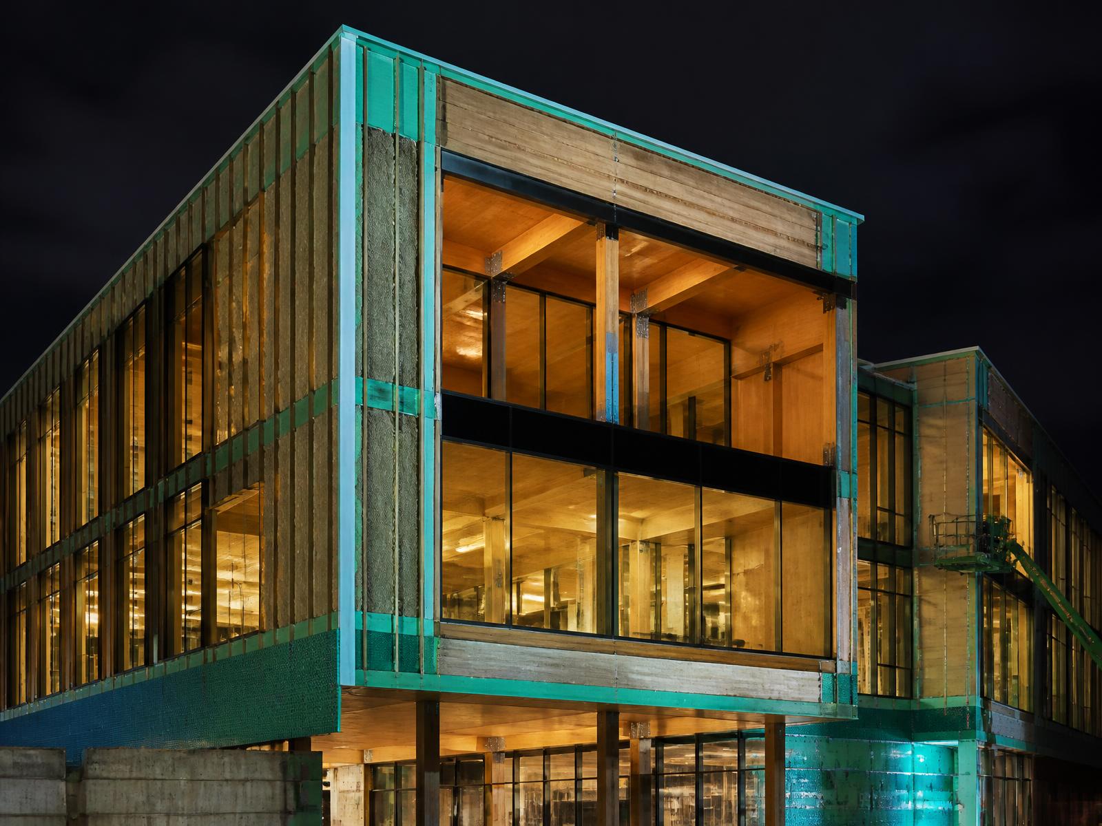 High-performance mass-timber building at dusk with its insulated envelope layers exposed.